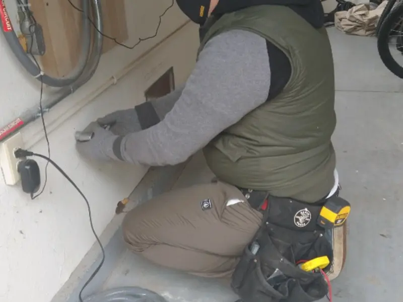 Electrician performing outlet wiring in a Westwood Lakes garage